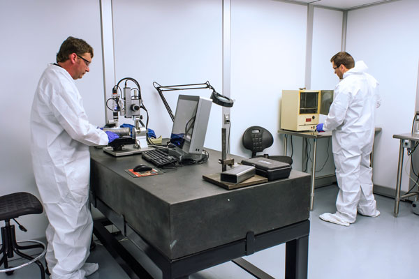 Two specialists processing and testing in ALMCO lab.