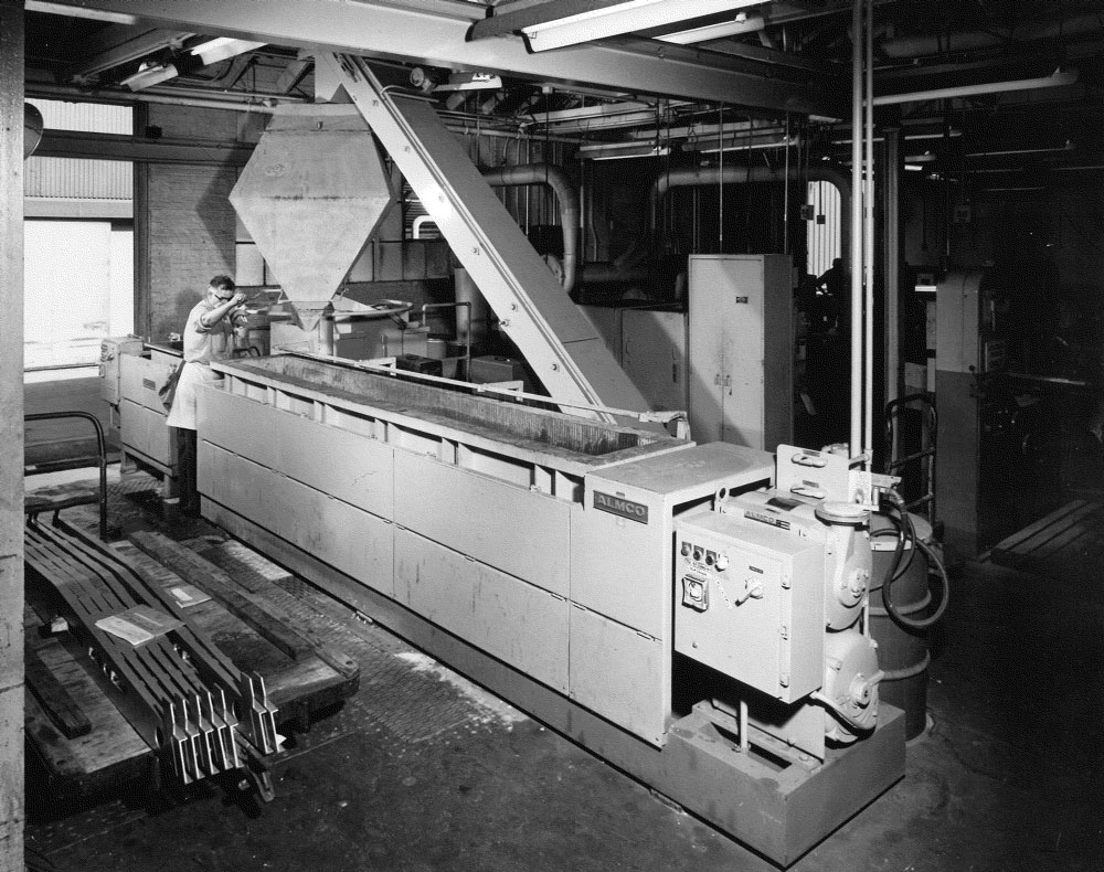 Engineer operates finishing machine as it outputs parts